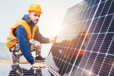 Arbeiter auf einem Dach mit Solarmodulen