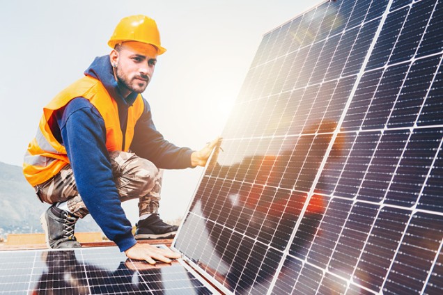 Arbeiter auf einem Dach mit Solarmodulen
