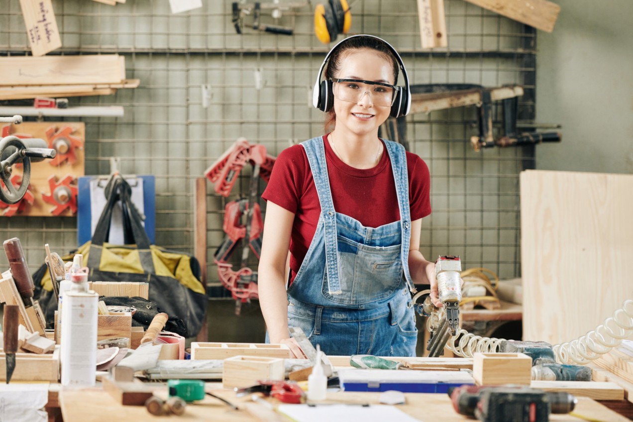 Junge Frau arbeitet in einer Werkstatt