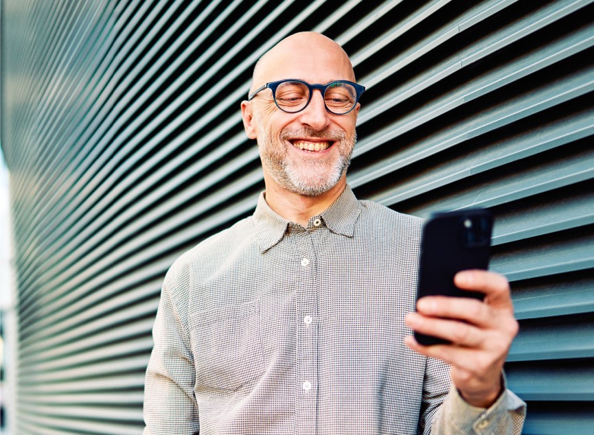 Mann mit Brille guckt auf sein Smartphone