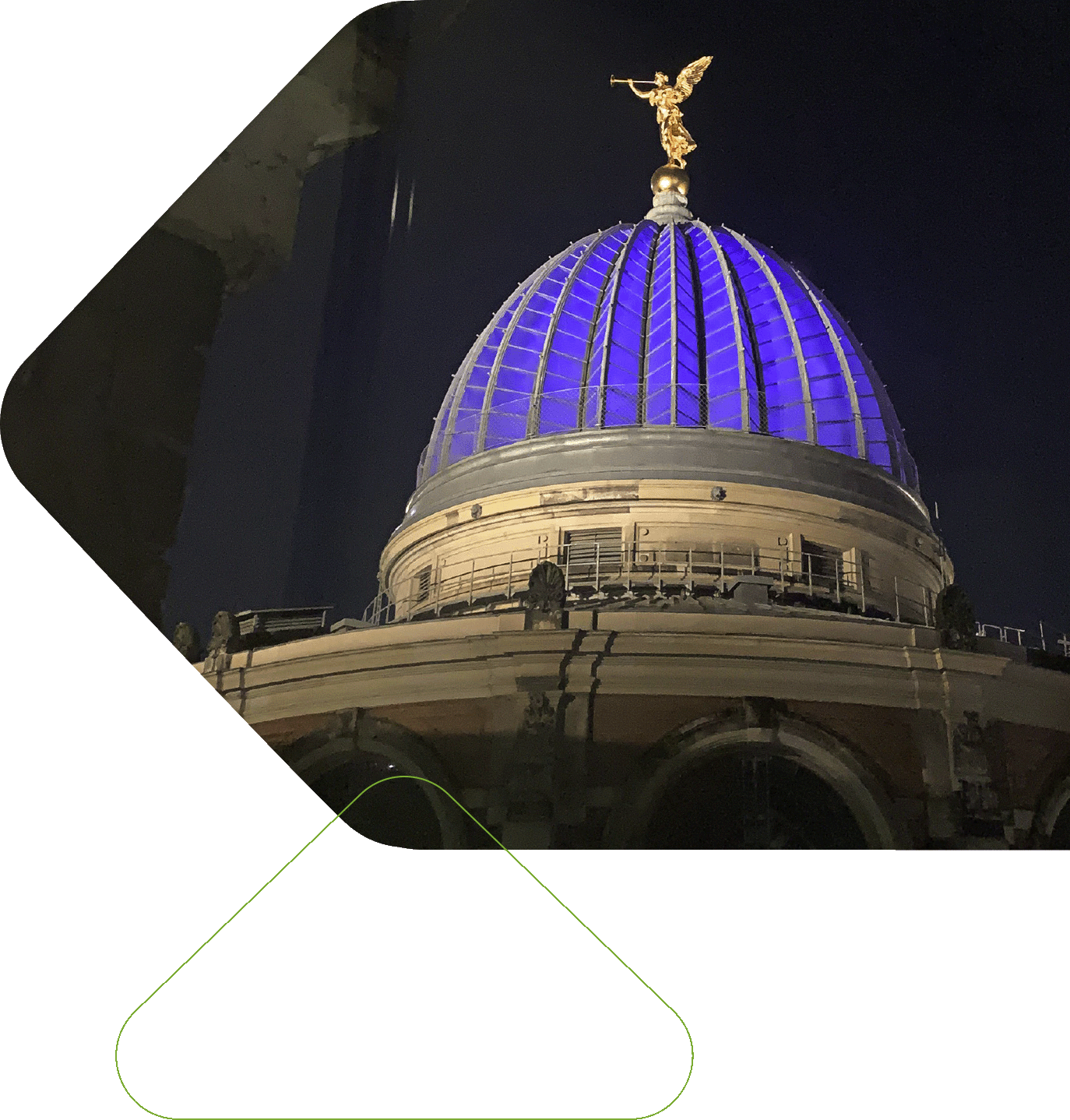 Nachtaufnahme der Kuppel eines alten Gebäudes. Auf der Spitze ein goldener Engel mit Trompete.